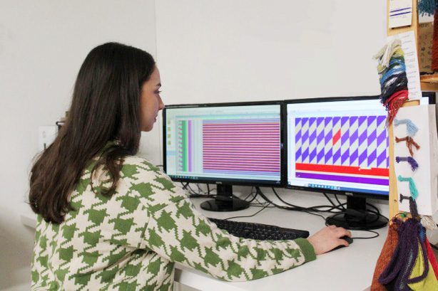 Jessica Turnbull working at a computer designing a knit layout