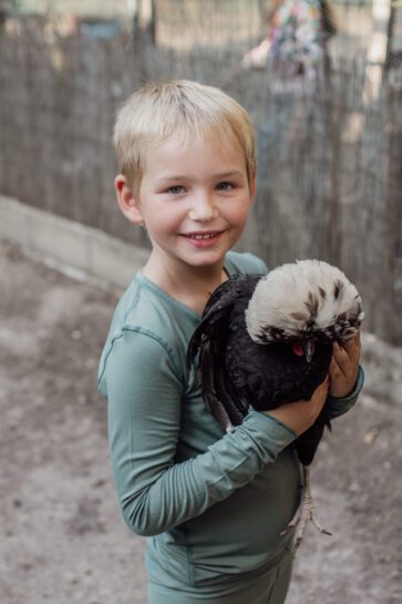 Morning Marvels- child holding a hen